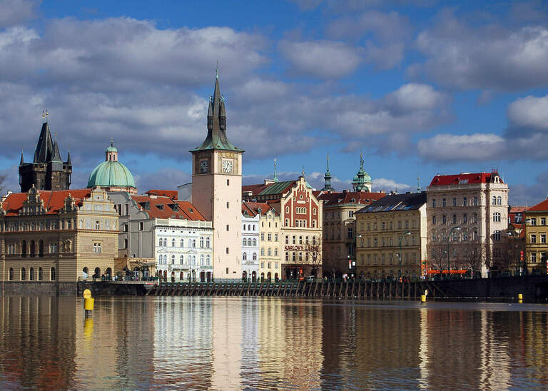 Die fließende Moldau in Prag mit Stadt im Hintegrund an einem schönen Tag