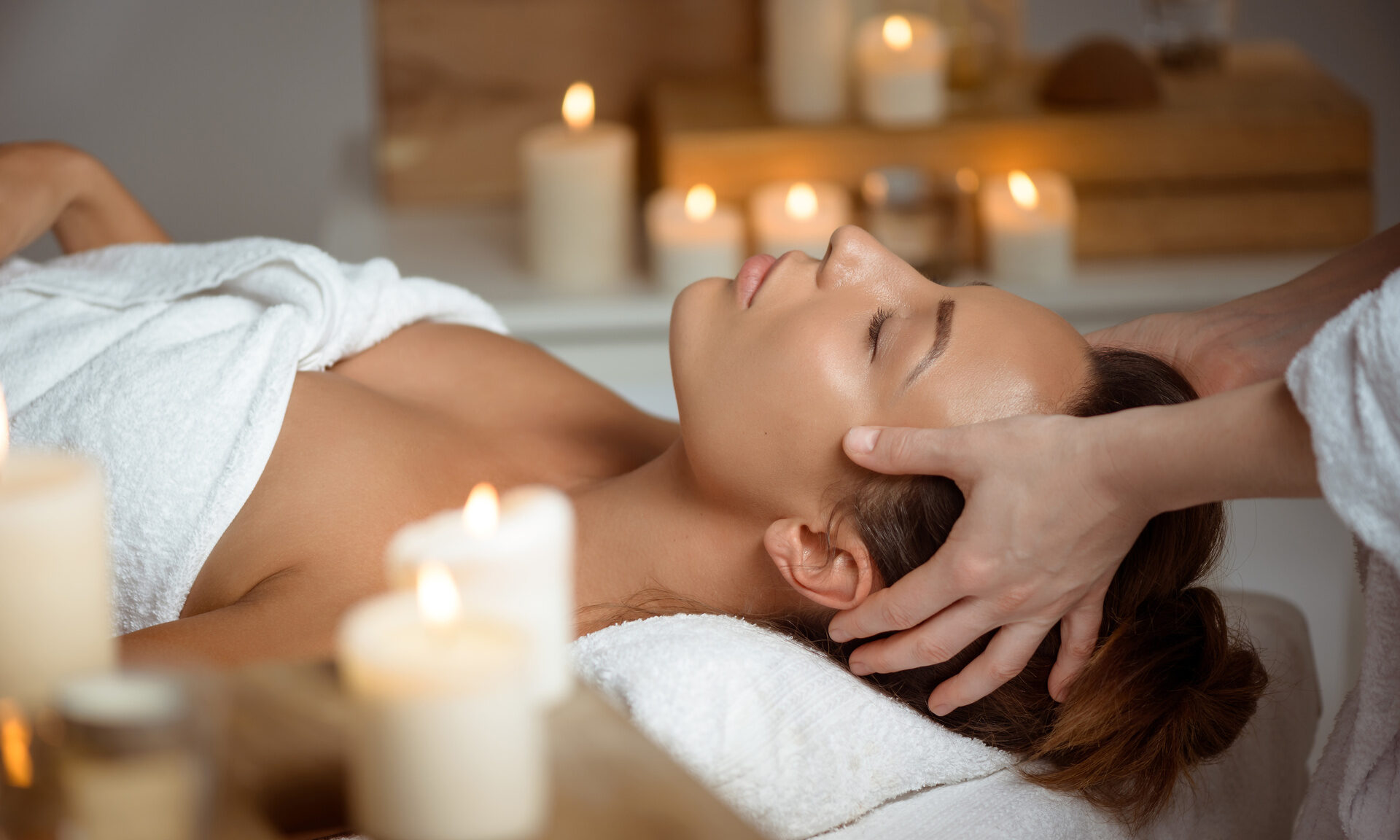 Eine Frau ruht sich auf einer Massageliege aus und genießt eine Massage im Wellnessbereich des Hotel Quellenhof.