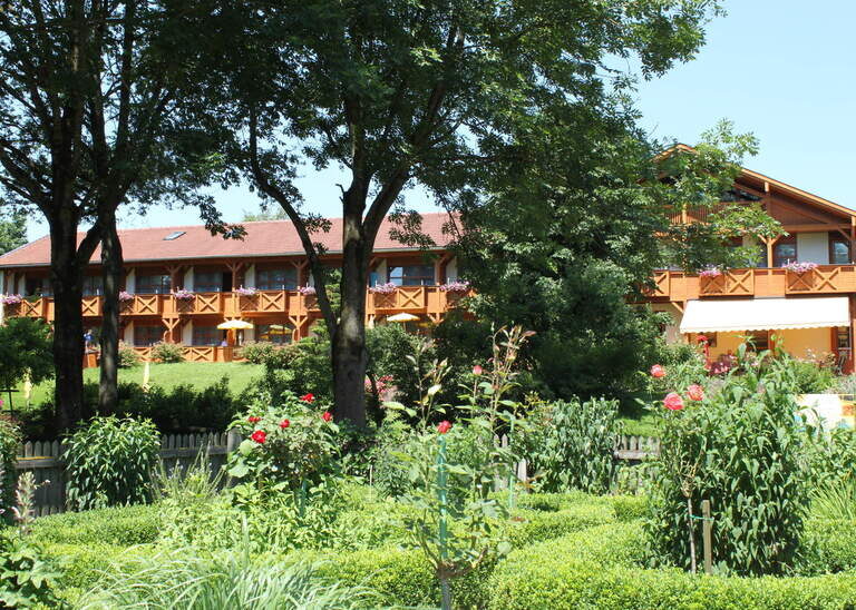 Der grüne und blühende Garten rund um das Hotel Quellenhof in Bad Birnbach an einem schönen sommerlichen Tag.