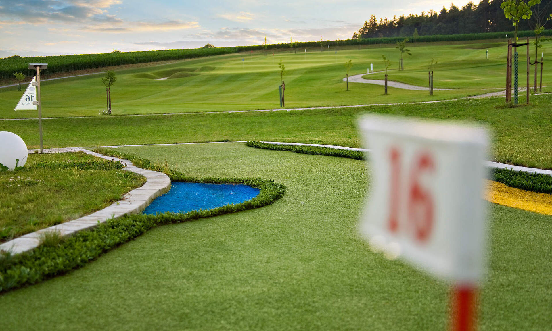 Mehrere Golfbahnen mit Flaggen und Hindernissen im Bella Vista Goflpark in Bad Birnbach.