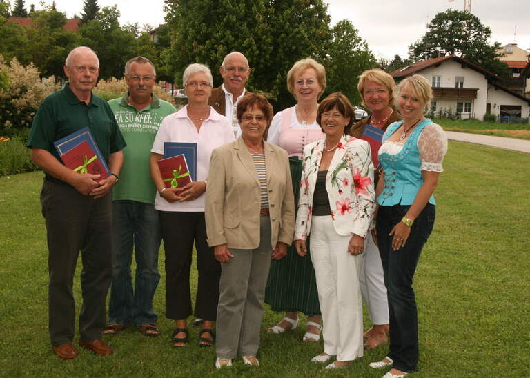 Eine Gruppe von Quellenhof-Gästen posiert für ein Ehrungsfoto im Freien.