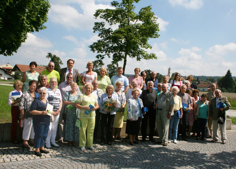 Mehrere Ehrengäste des Hotels Quellenhof in Bad Birnbach posieren vor einem Baum im Freien für ein Gruppenfoto.