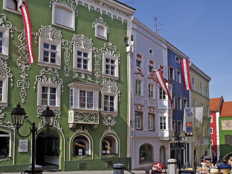 Eine Häuserreihe mit wehenden Fahnen an den Fassaden in der Innenstadt von Schärding.