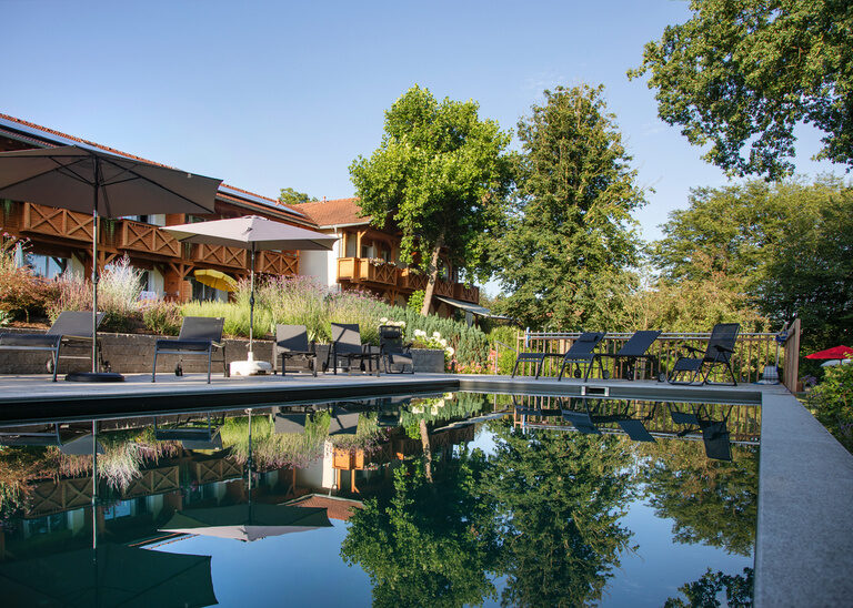 Wellnesshotel Quellenhof Bad Birnbach gespieglt im Naturpool des Hotels.