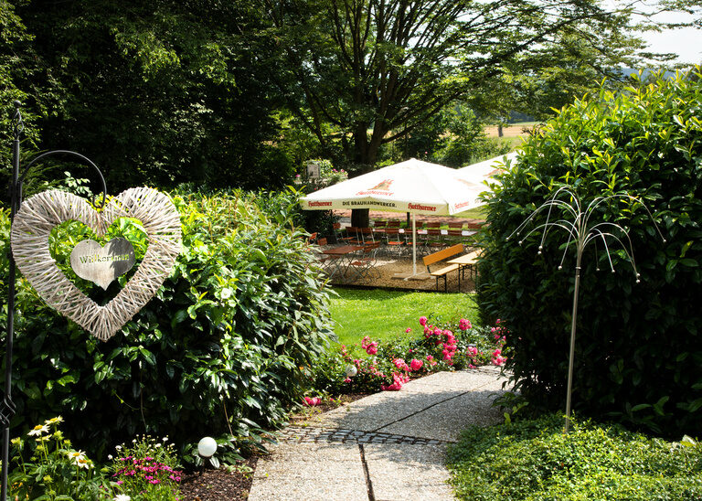 Ein Garten mit vielen Blüten und Sträuchern im Erholungsbereich des Hotel Quellenhof.