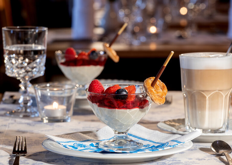 Appetitlich angerichtete Desserts mit einem Glas Latte Macchiato im Restaurant des Hotel Quellenhof.