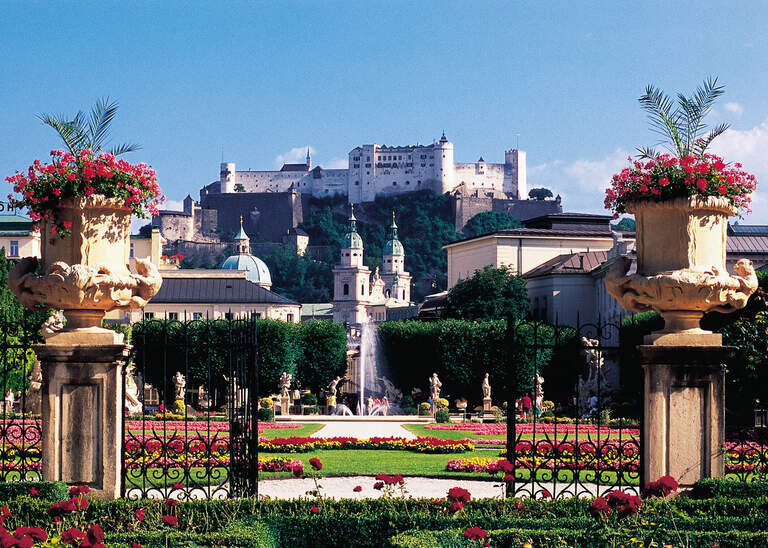 Der Mirabellgarten in Salzburg  mit Schloss Mirabell im Hintergrund an einem schönen Tag.