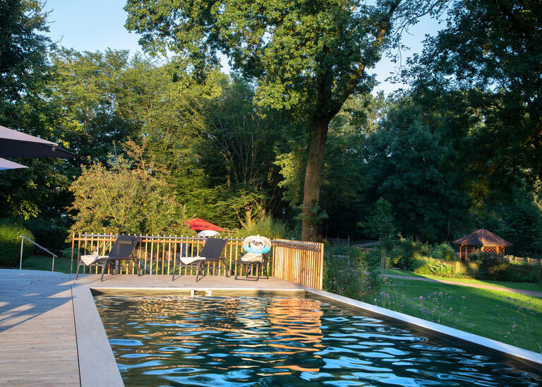 Naturpool mit Terrasse und Gartenbereich des Hotel Quellenhof in Bad Birnbach.