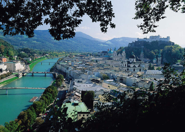 Die Stadt Salzburg gesehen von einem Berg aus mit dem Fluss Salzach.