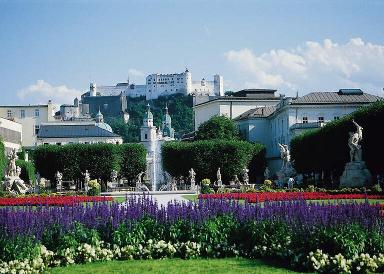 Das Schloss Mirabell in Salzburg mit schickem und blühenden Mirabllgarten im Vordergrund.