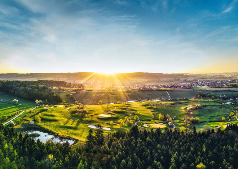 Blick auf den Bella Vista Golfpark in Bad Birnbach während im Hintergrund die Sonne untergeht.